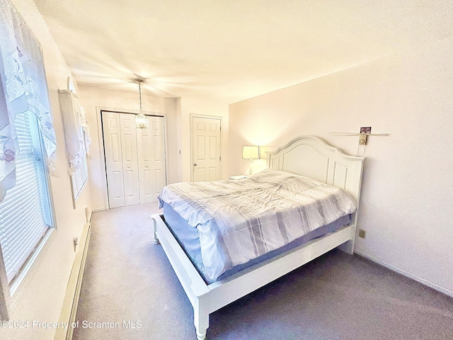 bedroom featuring carpet, a chandelier, a baseboard radiator, and a closet