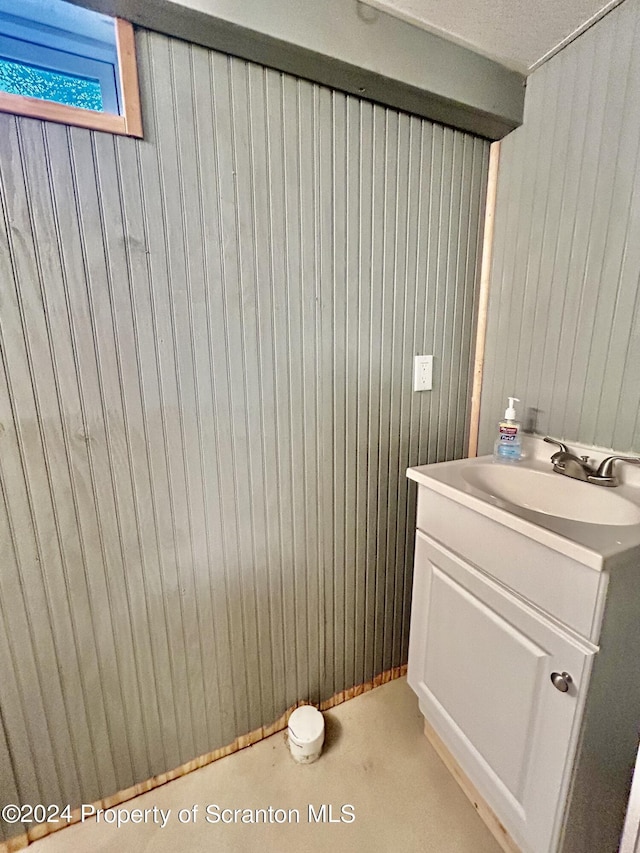 bathroom featuring vanity and wooden walls