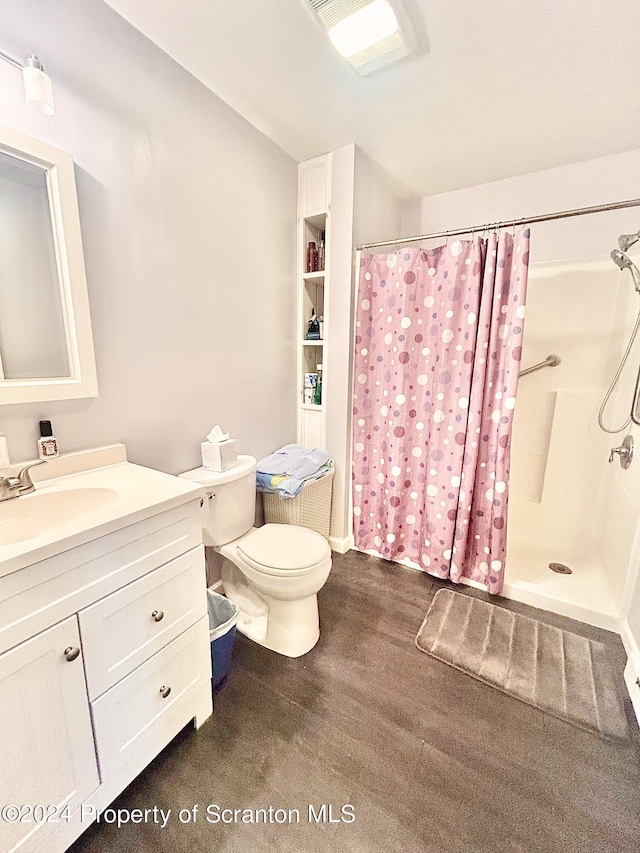 bathroom featuring vanity, curtained shower, and toilet