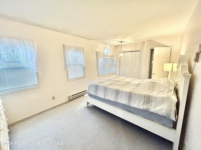 bedroom featuring carpet, baseboard heating, and a closet