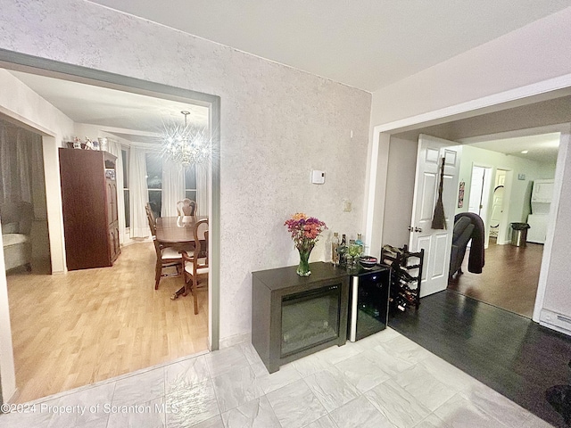 hall featuring light hardwood / wood-style floors and an inviting chandelier