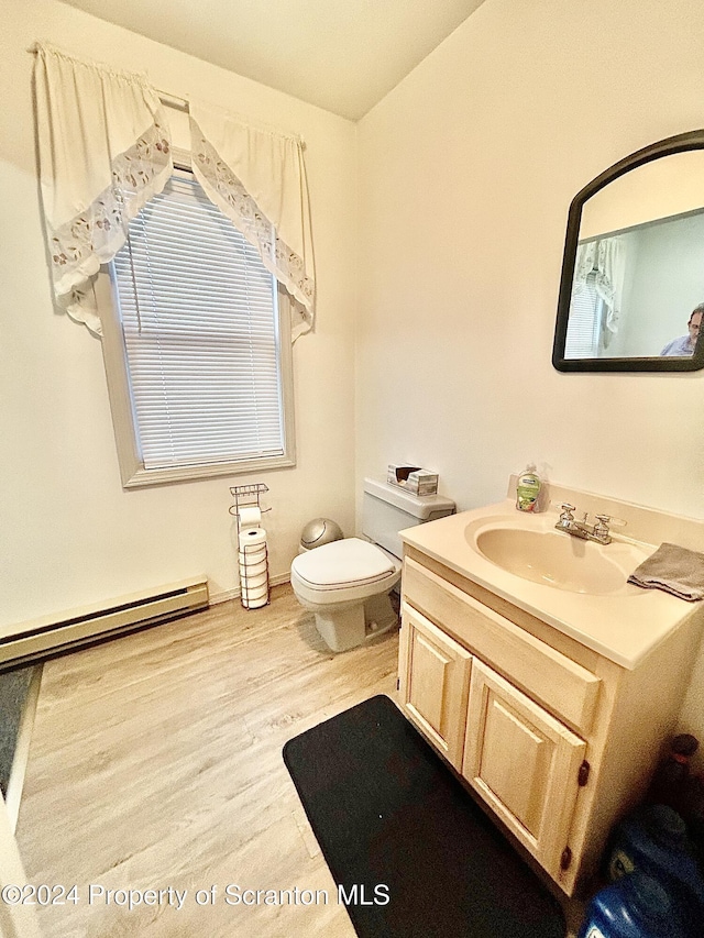 bathroom featuring vanity, toilet, wood-type flooring, and a baseboard radiator