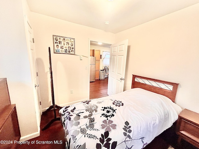 bedroom with white fridge and hardwood / wood-style flooring