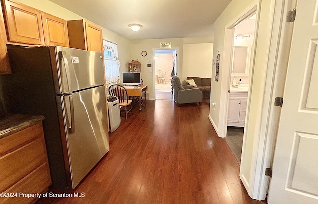 kitchen featuring stainless steel fridge, light brown cabinetry, and dark hardwood / wood-style floors