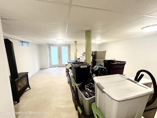 basement with a paneled ceiling and french doors