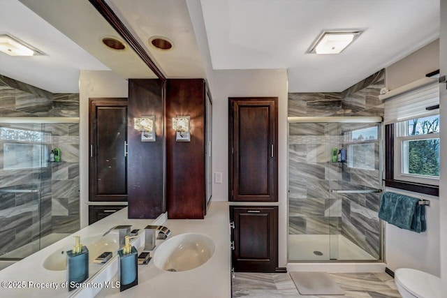 bathroom featuring toilet, vanity, and a shower with shower door