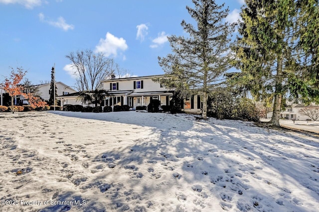 view of snow covered rear of property