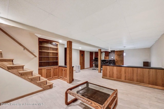 living room featuring built in shelves and light hardwood / wood-style floors