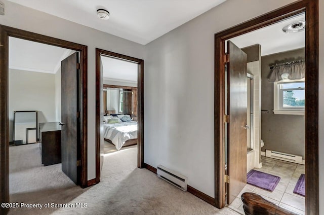 corridor with light colored carpet and baseboard heating