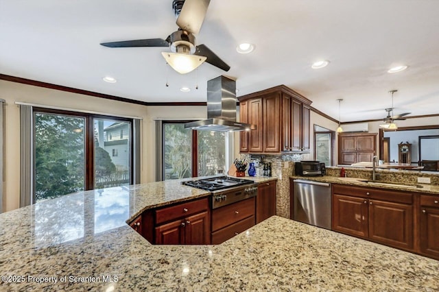 kitchen with sink, island range hood, appliances with stainless steel finishes, ornamental molding, and light stone countertops