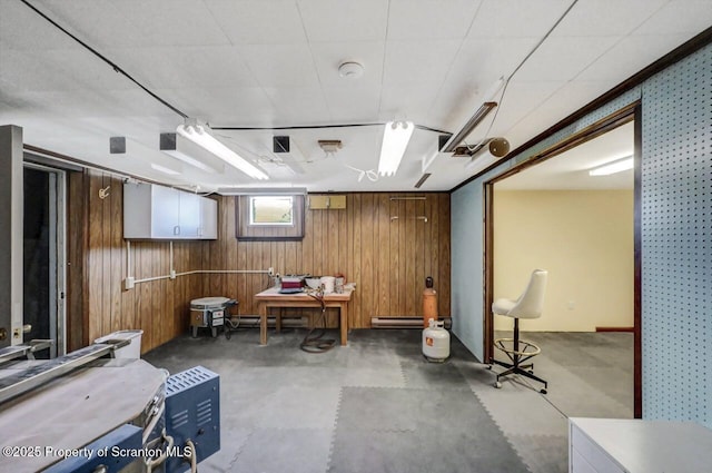 basement with a baseboard radiator and wood walls