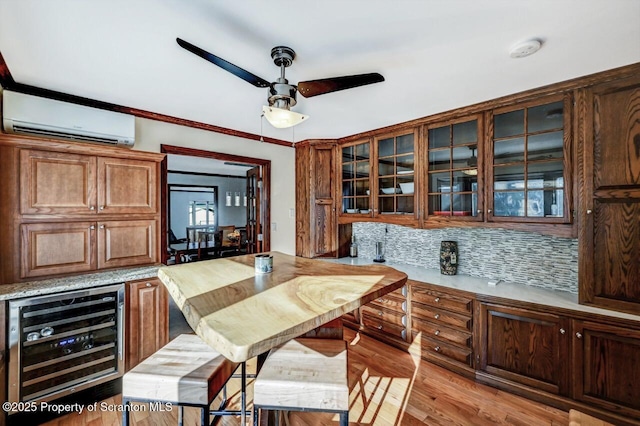 kitchen featuring ceiling fan, wine cooler, a wall mounted air conditioner, light hardwood / wood-style floors, and decorative backsplash