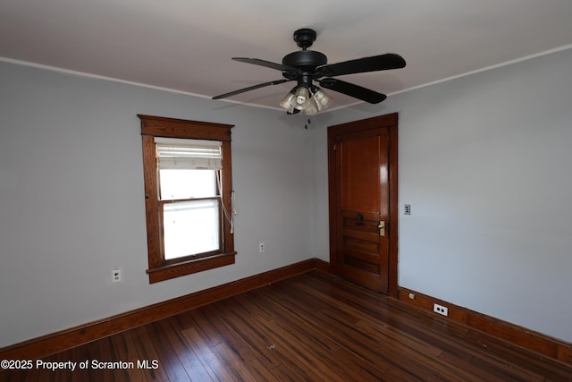 empty room featuring ceiling fan, baseboards, dark wood-style floors, and crown molding