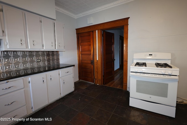 kitchen featuring an ornate ceiling, dark countertops, white cabinets, and white gas range oven