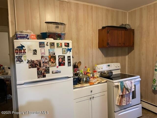 kitchen with a baseboard heating unit, wood walls, white appliances, and light countertops