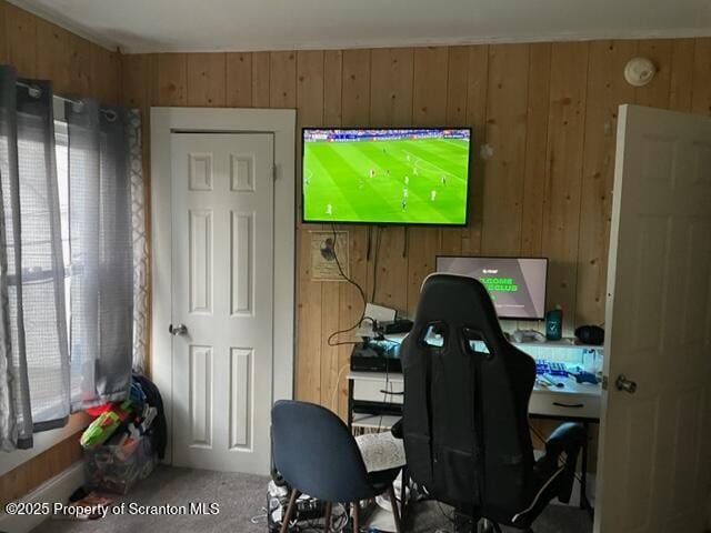 carpeted office featuring wood walls
