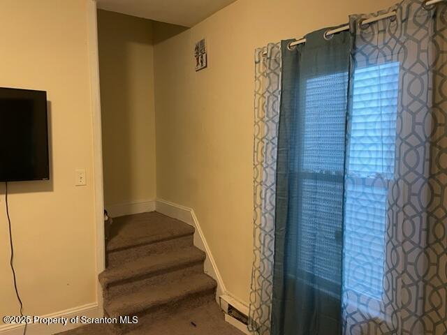 staircase featuring baseboards