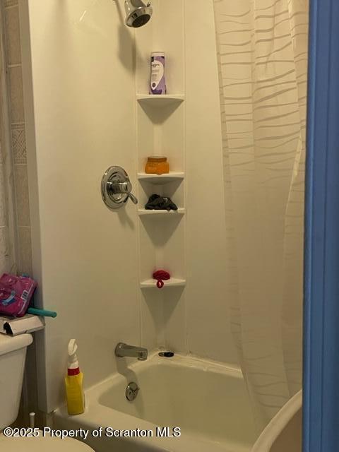 bathroom with toilet and shower / bath combination with curtain