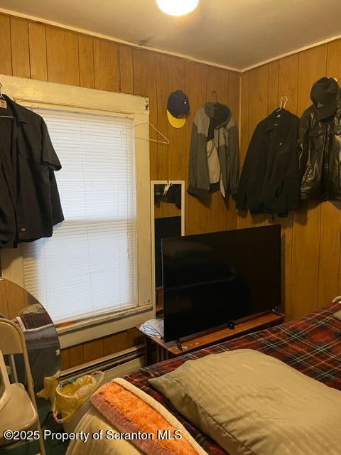 bedroom featuring wooden walls
