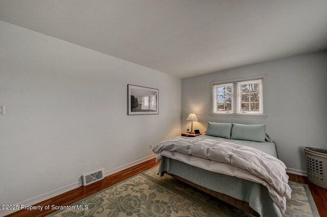 bedroom featuring dark wood-style floors, baseboards, and visible vents