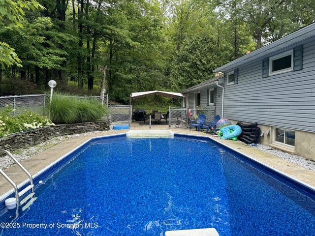 view of swimming pool with fence and a gazebo