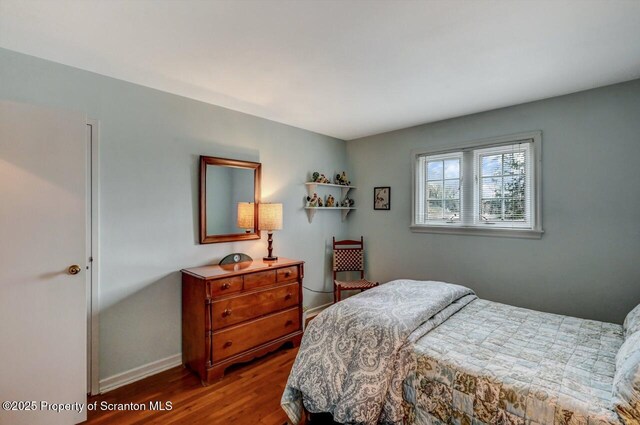 bedroom with baseboards and wood finished floors