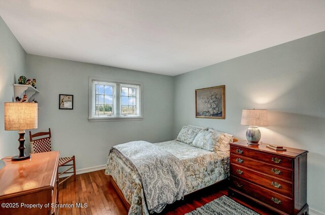 bedroom with baseboards and wood finished floors