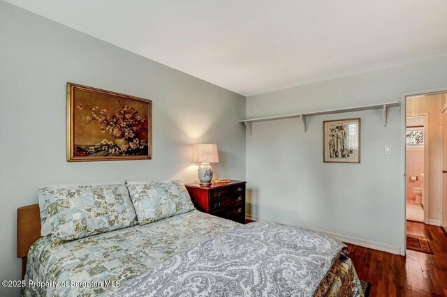 bedroom featuring dark wood-type flooring and baseboards