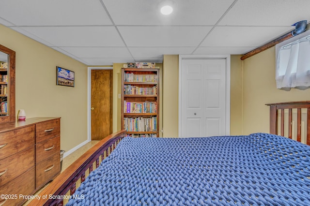 bedroom with a paneled ceiling and a closet