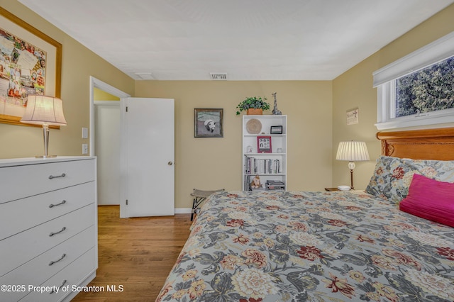 bedroom with light wood-style flooring and visible vents