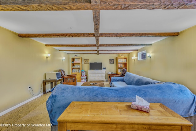 living area featuring baseboards and beam ceiling