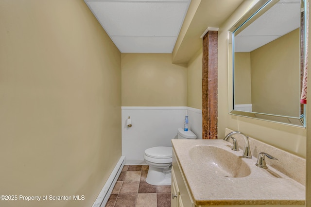 bathroom featuring toilet, baseboards, baseboard heating, and vanity