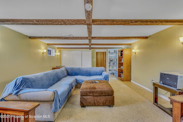 living room featuring visible vents, beamed ceiling, and baseboards