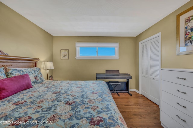 bedroom with a closet, baseboards, and wood finished floors