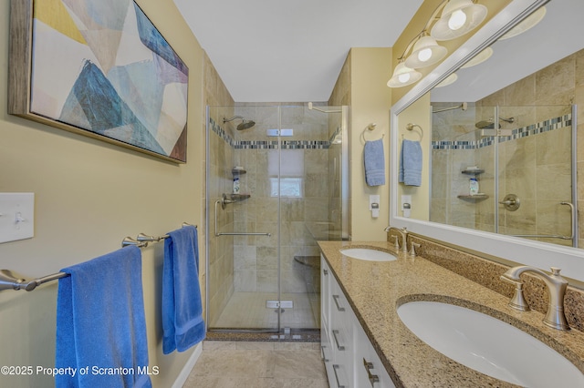 full bath with double vanity, a sink, and a shower stall