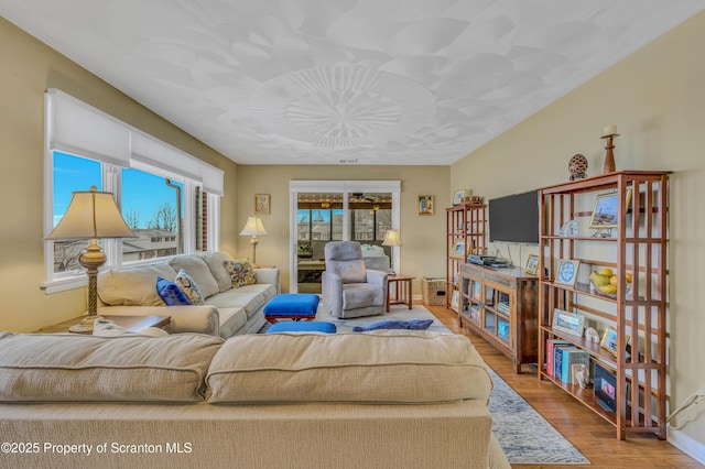 living area featuring baseboards and wood finished floors