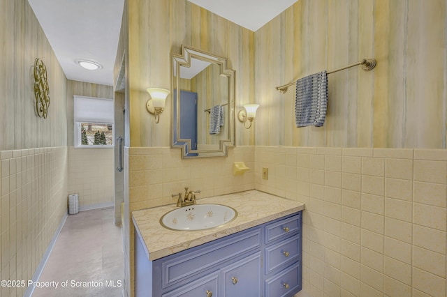 bathroom featuring tile patterned flooring, vanity, and tile walls