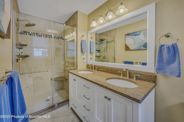 bathroom with double vanity, a shower stall, and a sink