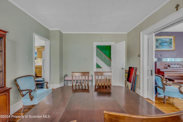 dining area with hardwood / wood-style floors and ornamental molding