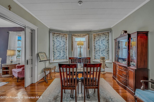 dining room with light wood-type flooring and crown molding