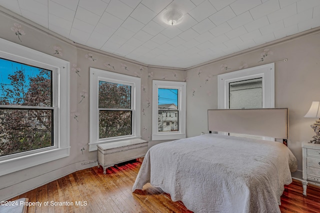 bedroom featuring ornamental molding and hardwood / wood-style flooring