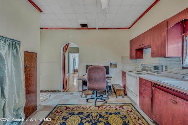 kitchen with sink, electric range, crown molding, and backsplash