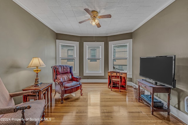 living area with ceiling fan, light wood-type flooring, and ornamental molding