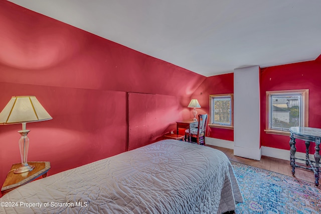 bedroom featuring hardwood / wood-style flooring and lofted ceiling