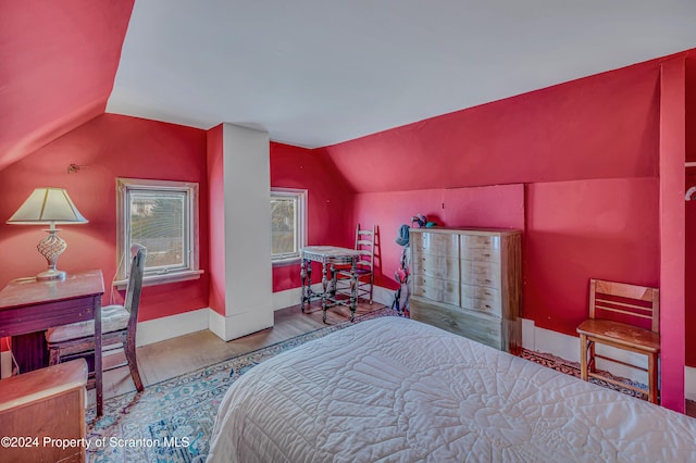 bedroom with hardwood / wood-style floors and vaulted ceiling