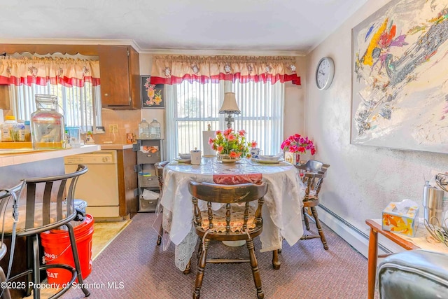 dining room with a baseboard heating unit, crown molding, and a wealth of natural light