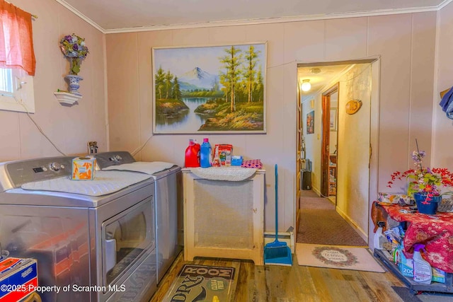 washroom with hardwood / wood-style floors, crown molding, and washing machine and dryer