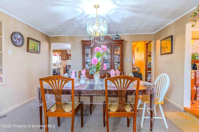 carpeted dining room with ornamental molding and a notable chandelier