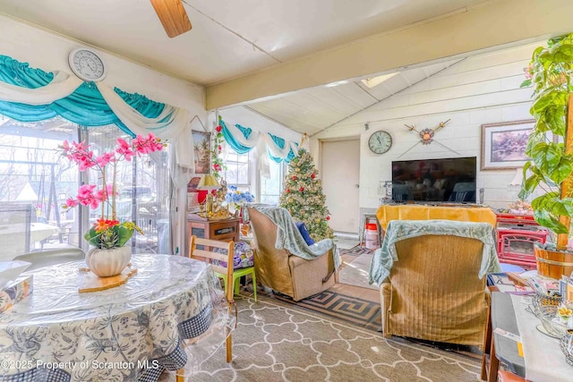 living room featuring ceiling fan and lofted ceiling with beams