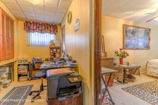 home office with ceiling fan, a paneled ceiling, and carpet floors